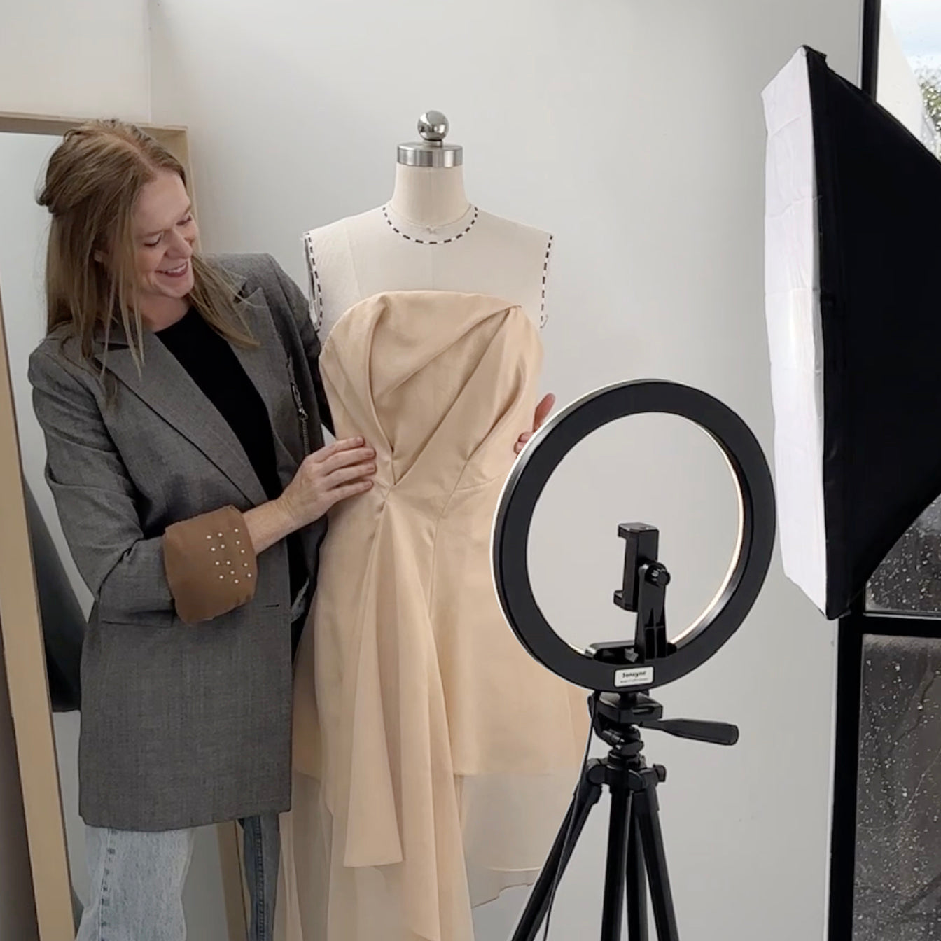 Leigh Goyen filming a pattern making tutorial for YouTube video — draping a toile on a dress form in her studio